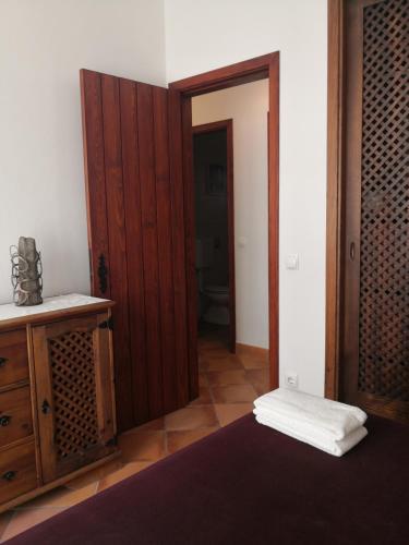 a room with a wooden door and a bathroom at Casa do Suberco in Nazaré