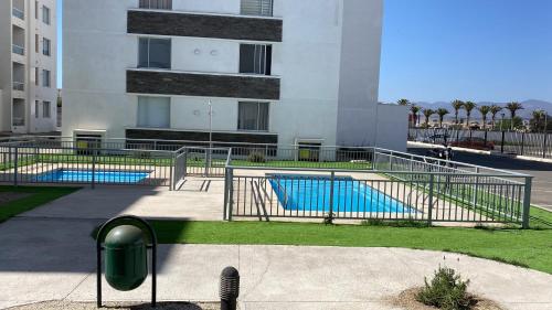 a building with two swimming pools in front of a building at Cond. Portal pacifico III in La Serena