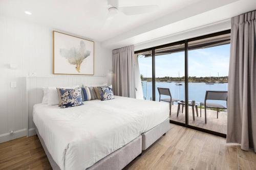 a bedroom with a large bed and a large window at Commodore Apartment 5, Noosa Heads in Noosa Heads