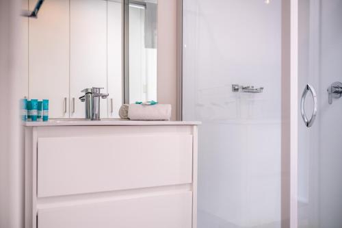 biała łazienka z umywalką i prysznicem w obiekcie Mayson w mieście Coles Bay