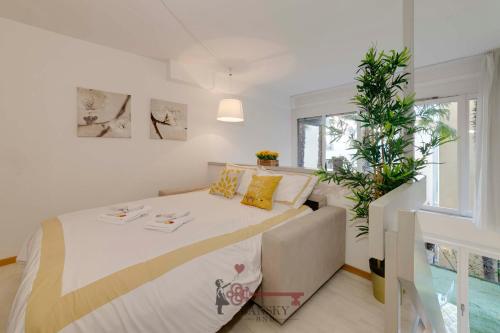 a bedroom with a bed and a plant at Soleil 5 Apt with Green Terrace in Lugano Center -By EasyLife Swiss in Lugano