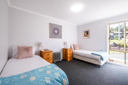 sypialnia z łóżkiem i oknem w obiekcie Mayson w mieście Coles Bay