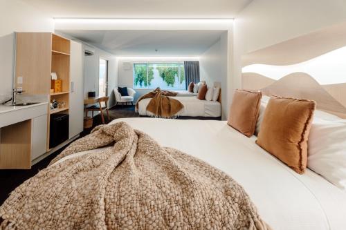 CitySide Hotel Tauranga في تاورانجا: غرفة نوم بسريرين ومغسلة
