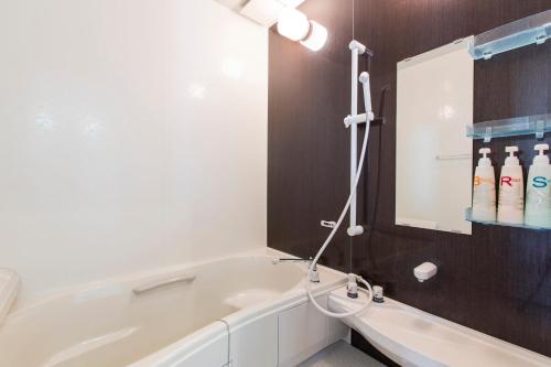 a bathroom with a bath tub and a mirror at Yotei Chalets in Niseko