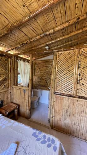 a room with a bed and a toilet in a building at Hostería El Sendero - Cocorná in Cocorná