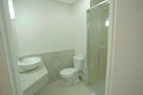 een badkamer met een toilet, een wastafel en een douche bij Goldmen Hotel Express in Cianorte