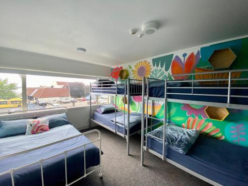 een kamer met 2 stapelbedden en een muurschildering bij Hello! Accommodation in Tauranga