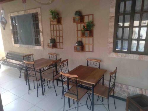 a restaurant with wooden tables and chairs in a room at Casa dos Cardoso in Maricá