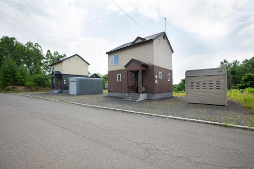 a house with a garage on the side of a street at Yotei Chalets in Niseko