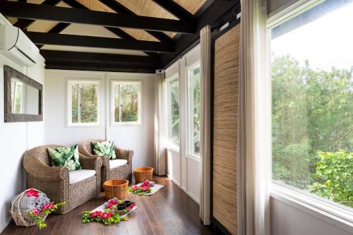 a screened in porch with two chairs and windows at Mantaray Island Resort in Nanuya Balavu Island