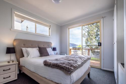 - une chambre avec un lit et une grande fenêtre dans l'établissement Wineglass, à Coles Bay