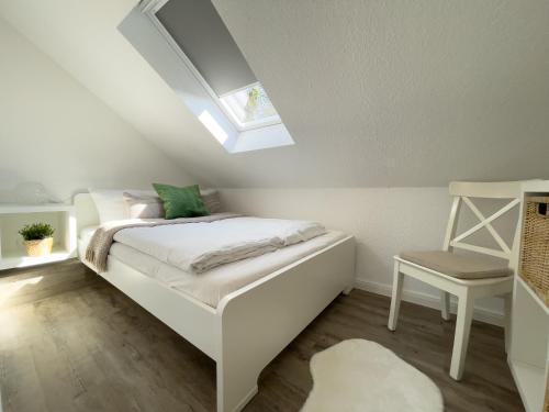 a small bedroom with a bed and a skylight at Kapitänshaus FeWo 3 in Cuxhaven