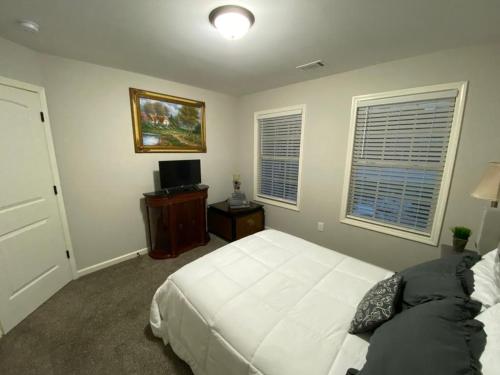 a bedroom with a white bed and a tv at Unwind in Winder in Winder