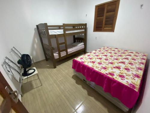 a bedroom with a bed and a chair in a room at Chácara Tantan - Martins RN in Martins
