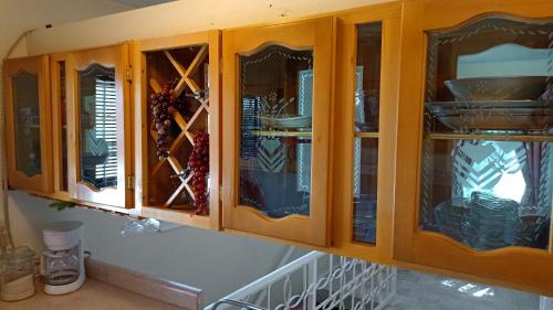 un armario de madera con puertas de cristal y platos en el interior en Departamento Valle Verde A 10 minutos consulado, en Ciudad Juárez
