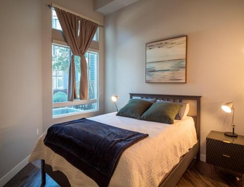 1 dormitorio con 1 cama con 2 lámparas y una ventana en Luxury Condo Fully Furnished Pool, Gym and Hot Tub en Mountain View
