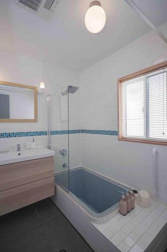 a bathroom with a tub and a sink and a shower at Hakuba Colonsay- Amazing views 3bdr 2bth cottage in Hakuba