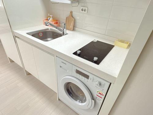 a kitchen with a washing machine and a sink at M studio Sondo Centralpark in Siheung