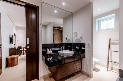 une salle de bains avec un lavabo et un miroir dans l'établissement Poppy Beachfront Residence, à Rawai Beach