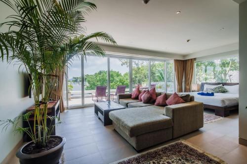 a living room with a couch and palm trees at Daisy 2 Bed Amazing Seaview in Rawai Beach