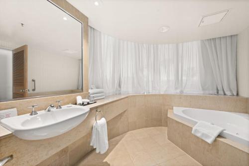 a bathroom with two sinks and a large mirror at Crowne Plaza Surfers Paradise, an IHG Hotel in Gold Coast