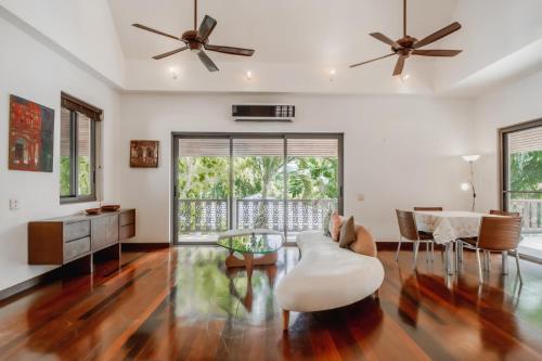 uma sala de estar com uma ventoinha de tecto e uma mesa e cadeiras em Orchid Pool Villa in Rawai em Praia de Rawai