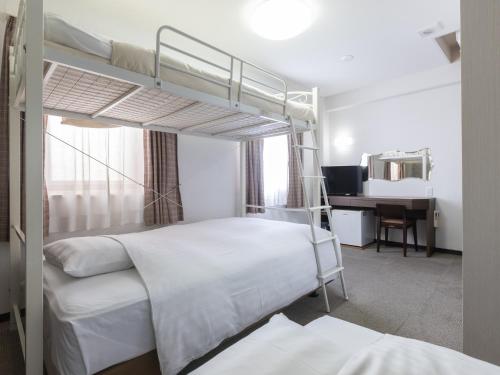 Sukagawa的住宿－須賀川永國際酒店，一间卧室配有两张双层床和一张书桌