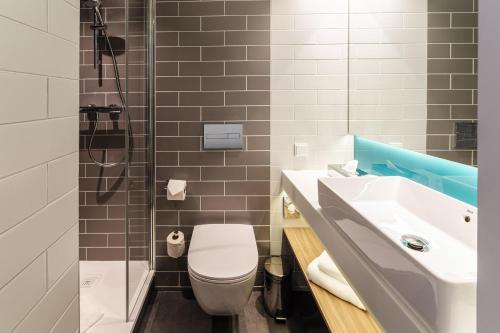 a bathroom with a sink and a toilet and a shower at Holiday Inn Express Dresden Zentrum by IHG in Dresden
