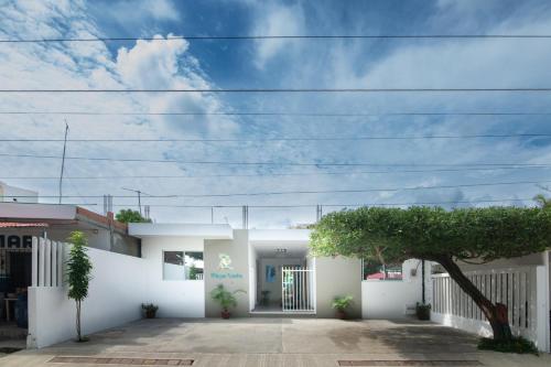 a white house with a tree in front of it at Habitacion Playa Linda 103 in Coveñitas