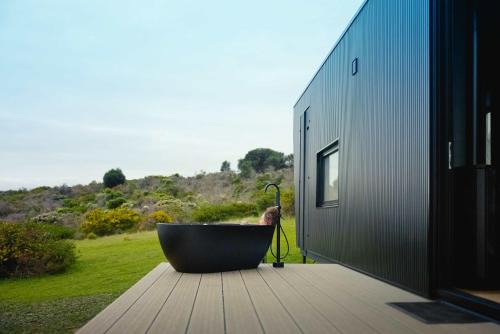 a bath tub sitting on a deck next to a building at CABN Kangaroo Island in Penneshaw