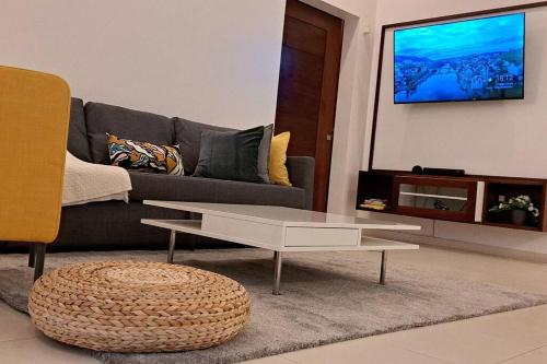 a living room with a couch and a coffee table at Deluxe villa with jacuzzi and beautiful garden in Santiago de los Caballeros