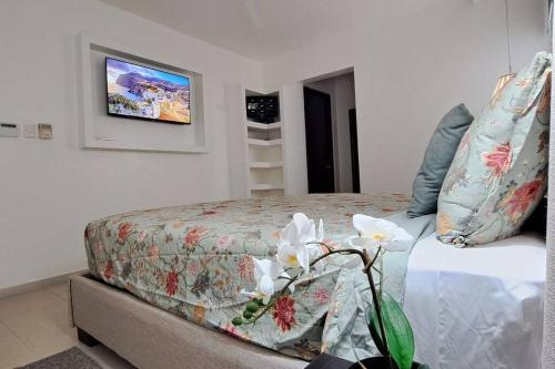 a bedroom with a bed and a tv on the wall at Deluxe villa with jacuzzi and beautiful garden in Santiago de los Caballeros
