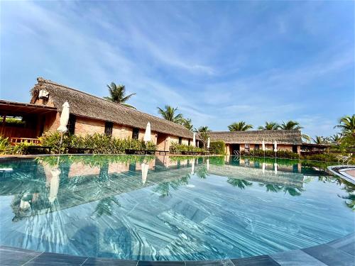 a swimming pool in front of a resort at ENSO Retreat Hoi An in Hoi An