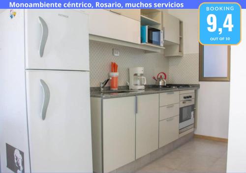a kitchen with white cabinets and a white refrigerator at Monoambiente Céntrico, Nuevo, Cochera y Muchos mas servicios in Rosario
