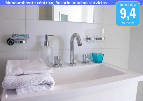 a bathroom sink with towels and a mirror at Monoambiente Céntrico, Nuevo, Cochera y Muchos mas servicios in Rosario