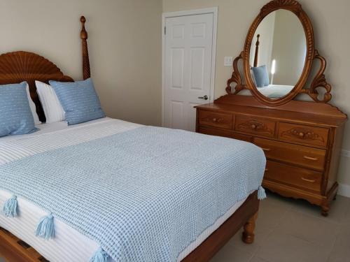 Dormitorio con cama con espejo y tocador en Ocean Pointe, Lucea, Hanova, Jamaica, en Lucea