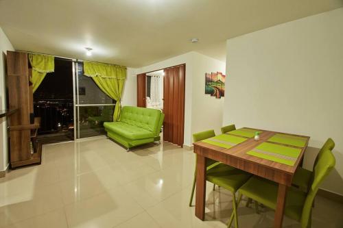 une salle à manger avec une table et une chaise vertes dans l'établissement Apartamento con Oficina, Cerca al Metro, à Sabaneta