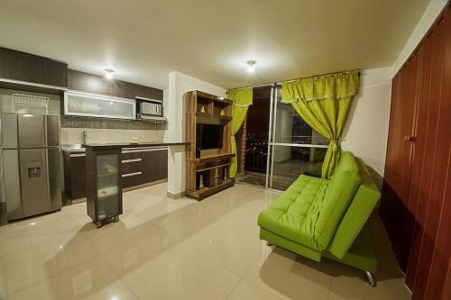 un salon avec un canapé vert dans une cuisine dans l'établissement Apartamento con Oficina, Cerca al Metro, à Sabaneta