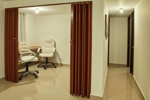 un cabinet médical avec une chaise et un miroir dans l'établissement Apartamento con Oficina, Cerca al Metro, à Sabaneta