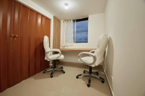 une salle de thérapie avec deux chaises et une fenêtre dans l'établissement Apartamento con Oficina, Cerca al Metro, à Sabaneta