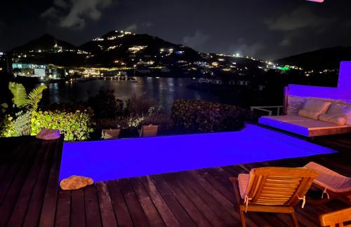 a blue bench on a deck with a view of the water at Villa CECILIA in Oyster Pond