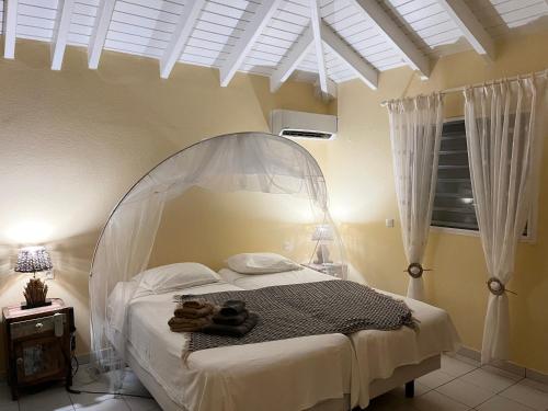 a bedroom with a bed with a white canopy at Villa CECILIA in Oyster Pond