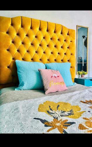 1 cama con cabecero grande acolchado naranja y almohadas en Tropical Dreams en Villahermosa