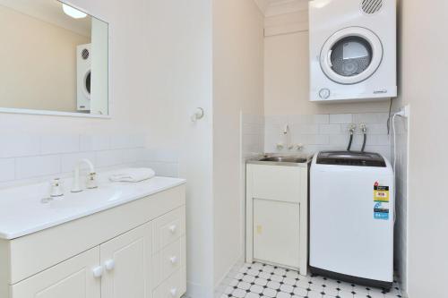 a white bathroom with a sink and a washing machine at Tabitha Hill Estate close to wineries and nature in Bellbird