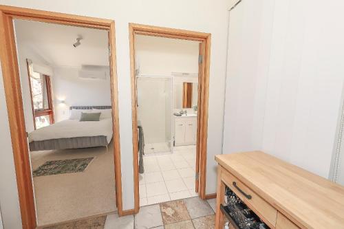 a bedroom with a bed and a mirror in a room at Nixon House in Benalla