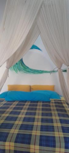 a bedroom with a bed with blue and white curtains at Blu oceano B&B, Italian restaurant in Nembrala