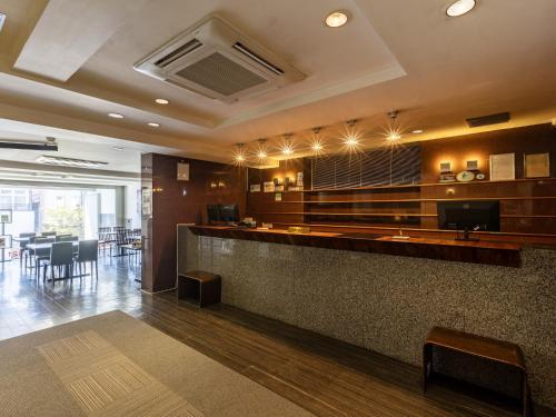 a restaurant with a bar with chairs and tables at KOKO STAY Sukagawa- formerly Hotel Wing International Sukagawa in Sukagawa