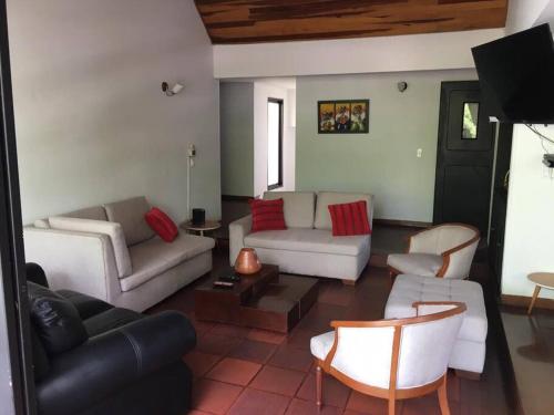 sala de estar con sofás, sillas y TV en Apartamento enorme y acogedor en Ibagué, en Ibagué