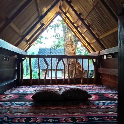 a bed with two pillows in a room with a window at Uma Villa Manado in Manado