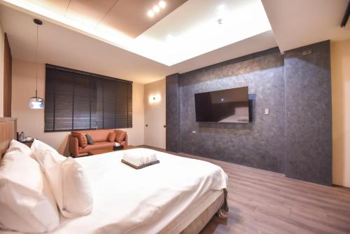 台南的住宿－貳侶休閒藝術旅館，一间卧室配有一张床,墙上配有电视